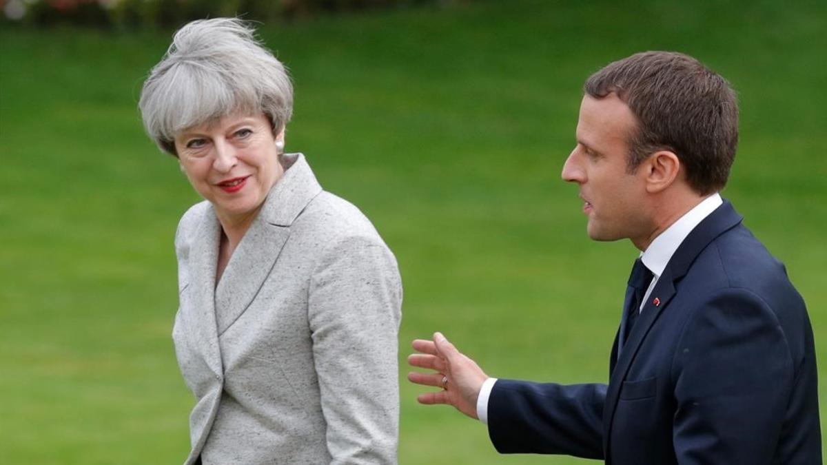 Macron (derecha) acompaña a May tras hablar con la prensa, en los jardines del Elíseo, en París, el 13 de junio.