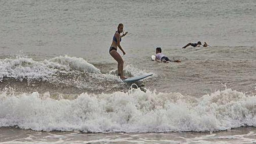 Una surfista sobre una ola, aprovechando el temporal.