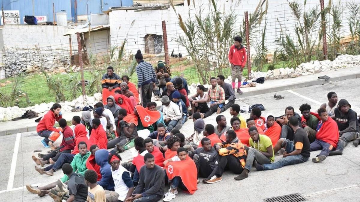 Inmigrantes detenidos en el barrio de El Tarajal en Ceuta tras lograr pasar la valla fronteriza.