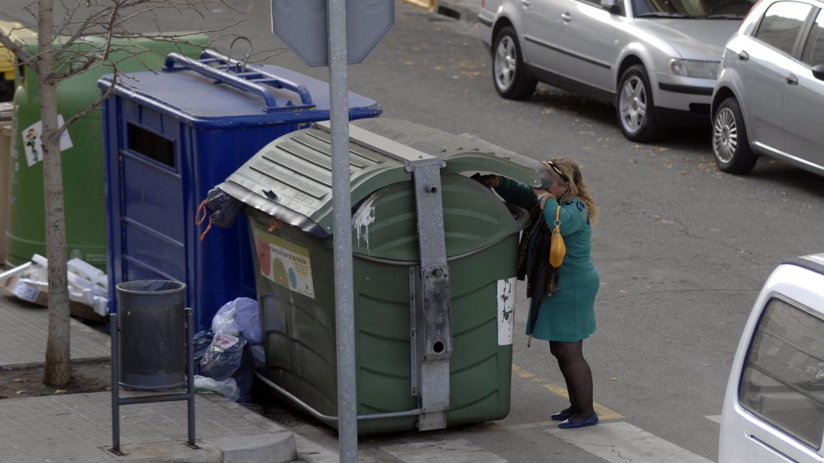 Una dona tirant la basura