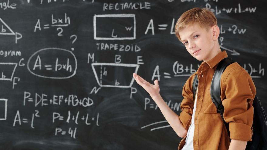 Un alumno, delante de una pizarra con operaciones matemáticas
