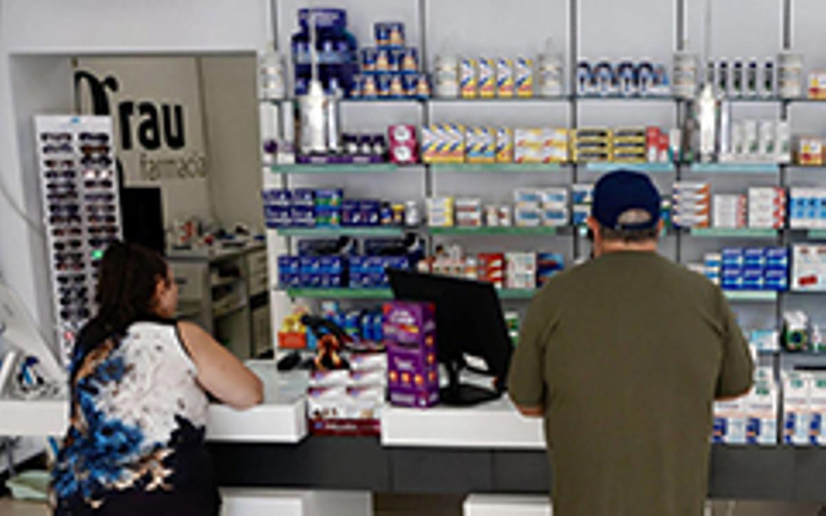 Dos clients esperen a ser atesos en una farmàcia.