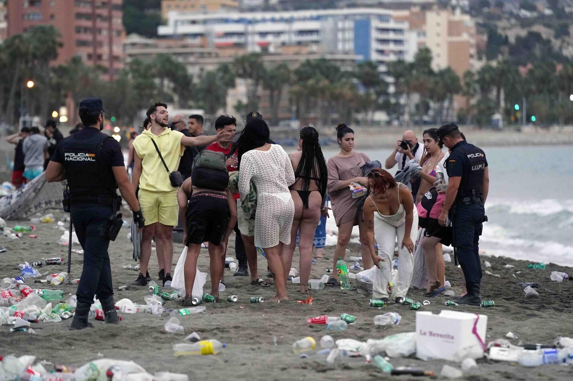 Varios operarios de la empresa de limpieza de Limasam, recogen los residuos de la playa de La Malagueta, tras la Noche de San Juan en Málaga 2025