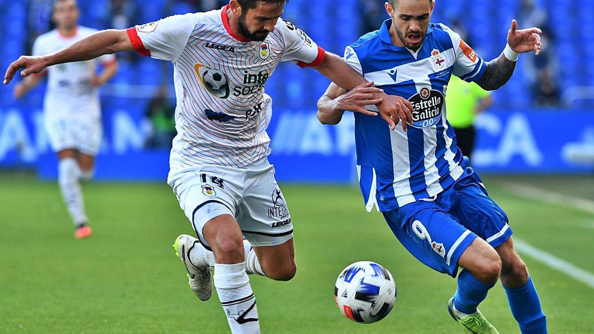 Rayco, en pugna con el balón con un futbolista visitante. |  // V. ECHAVE 