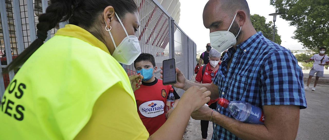 Un aficionado mallorquinista pasando el control sanitario para acceder a Son Moix, con el certificado covid digital en su móvil.