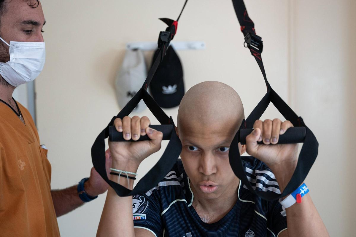 Steven, paciente con una leucemia, ejercita su musculatura junto a su fisioterapeuta, Denis.