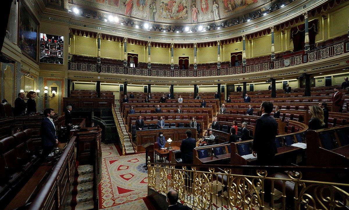 Miembros del Gobierno y diputados guardan un minuto de silencio por las víctimas del coronavirus, el 29 de abril en el Congreso.