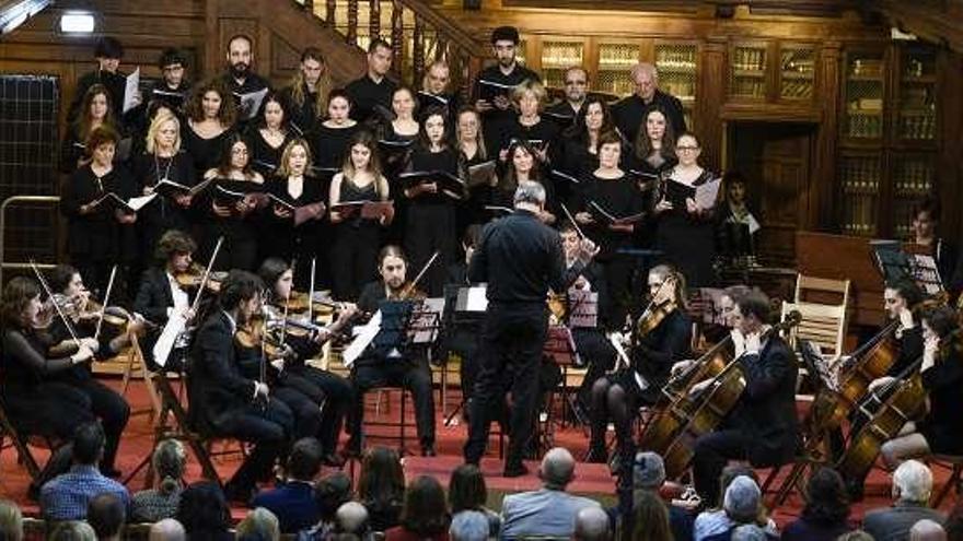 El Coro y la Orquesta de la Universidad dirigidos por Joaquín Valdeón, ayer, en la biblioteca del edificio histórico.