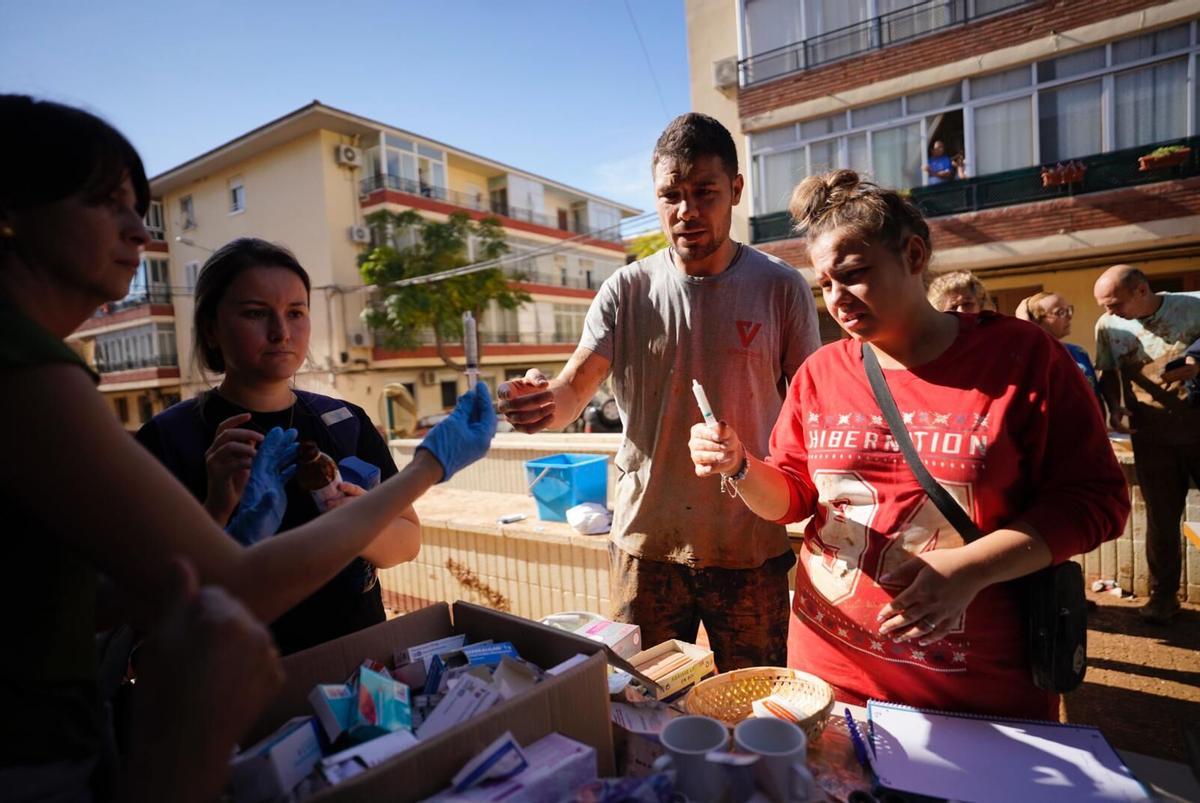 Personal médico entrega una jeringa con medicación en los días posteriores a la dana.