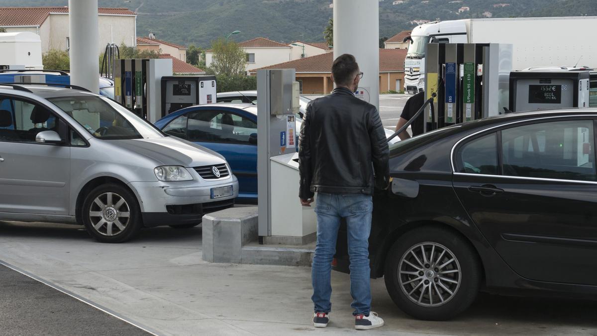 Un hombre pone gasolina en una estación de servicio.