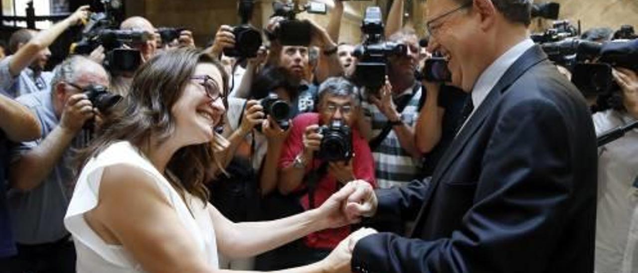 Mónica Oltra y Ximo Puig se saludan ayer ede forma efusiva en el Palau de la Generalitat