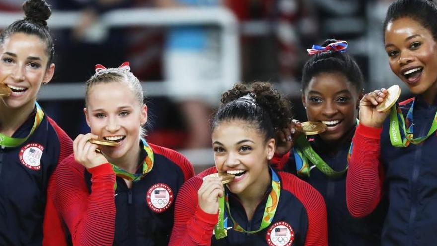 El equipo de gimnasia de EEUU, mordiendo sus medallas.