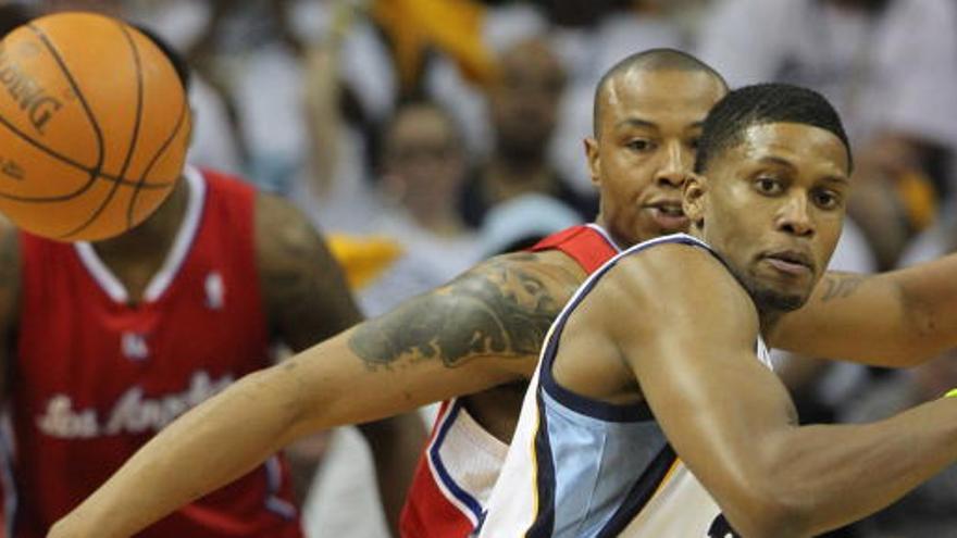 El jugador de los Clippers de Los Ángeles Caron Butler (atrás) busca una bola perdida ante Rudy Gay.