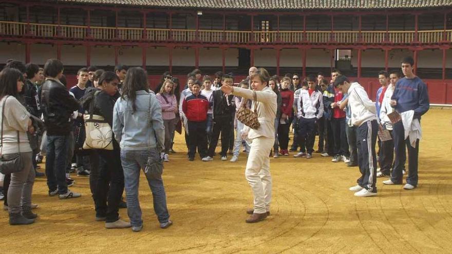 Una guía explica a un grupo de visitantes los datos históricos y características la plaza de toros. Foto