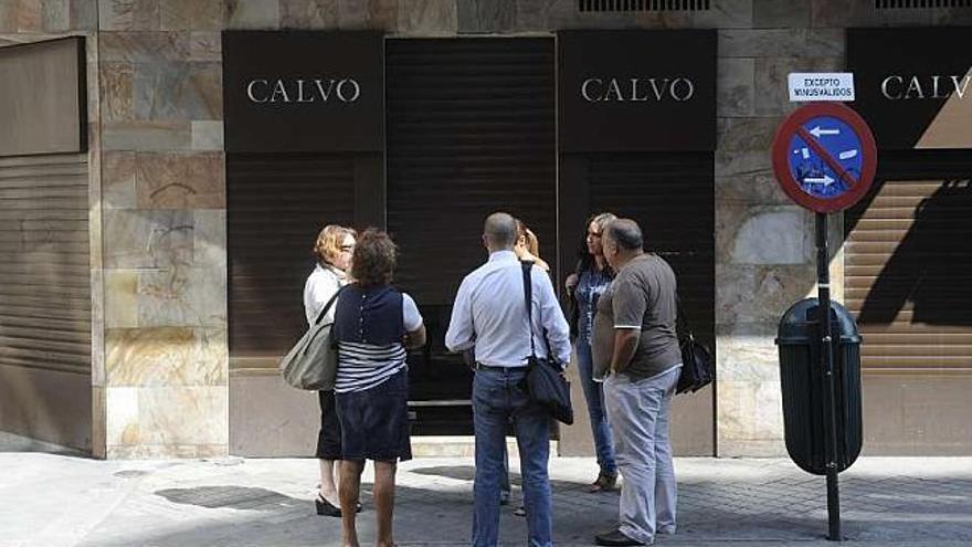 Arriba, el dueño y los empleados, ante la joyería. Abajo, destrozos cometidos durante el atraco. / c.pardellas-tvg