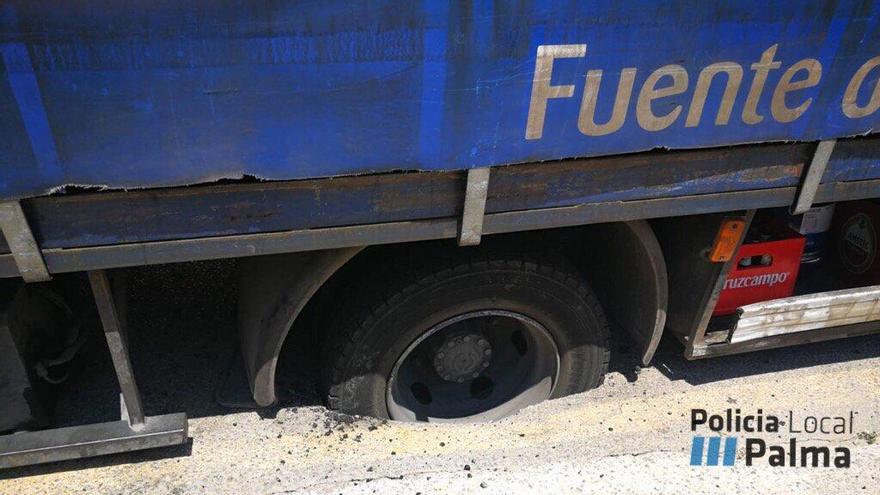 Un camión de reparto de agua embotellada, atrapado en un socavón en Can Pastilla