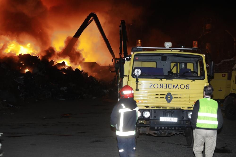 Labores de extinción del incendio de un desguace en Gijón