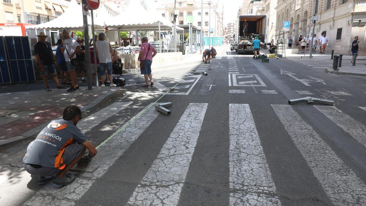 Operarios toman medidas antes de levantar una carpa.