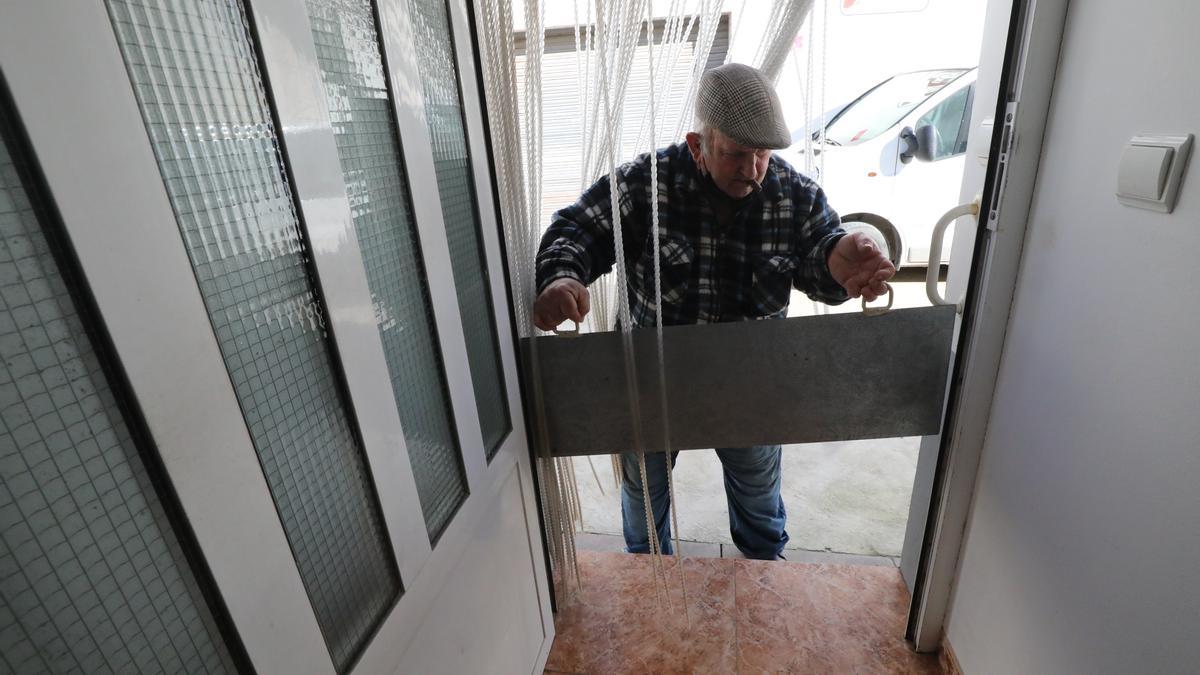 Ángel Cabestre, un vecino de Novillas colocando una tajadera en la puerta de su casa.