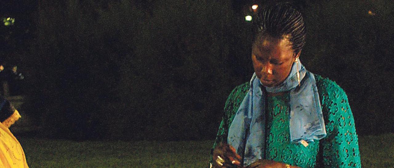 Una mujer subsahariana haciendo las trenzas a una niña.