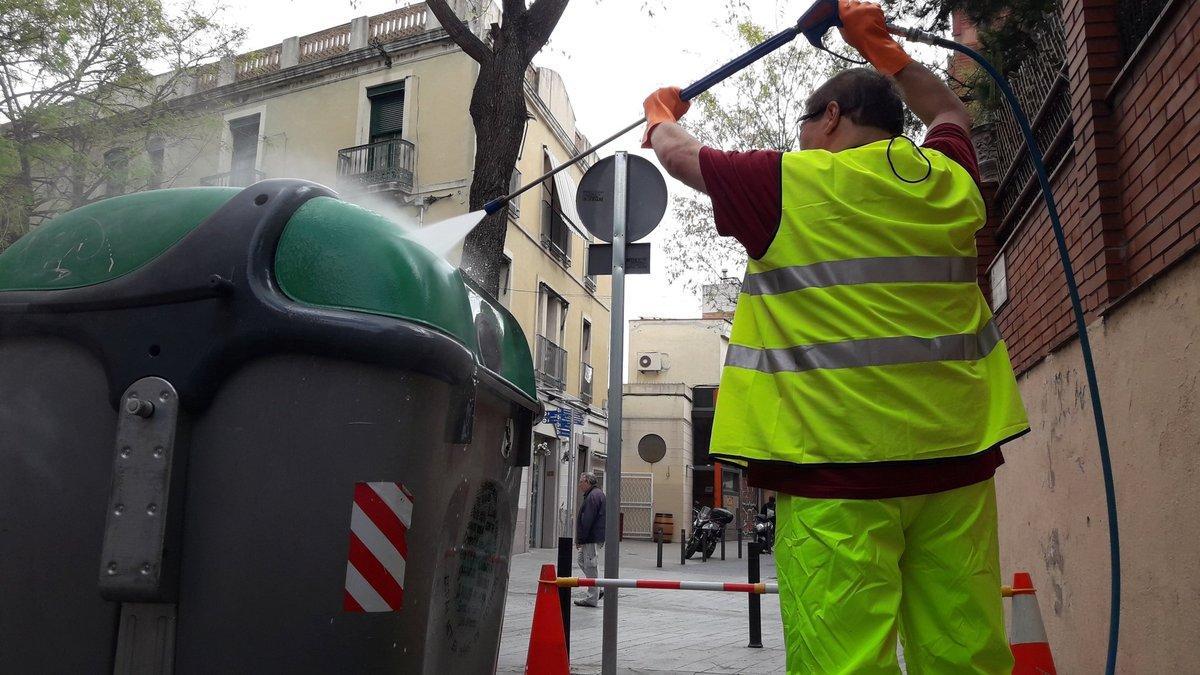 Un trabajador público limpiando el mobiliario urbano.