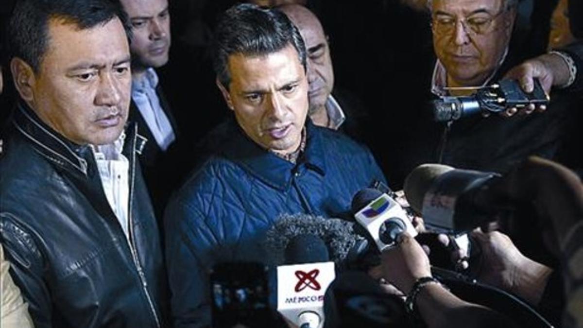 Enrique Peña (centro) atiende a la prensa frente a la sede de Pemex.