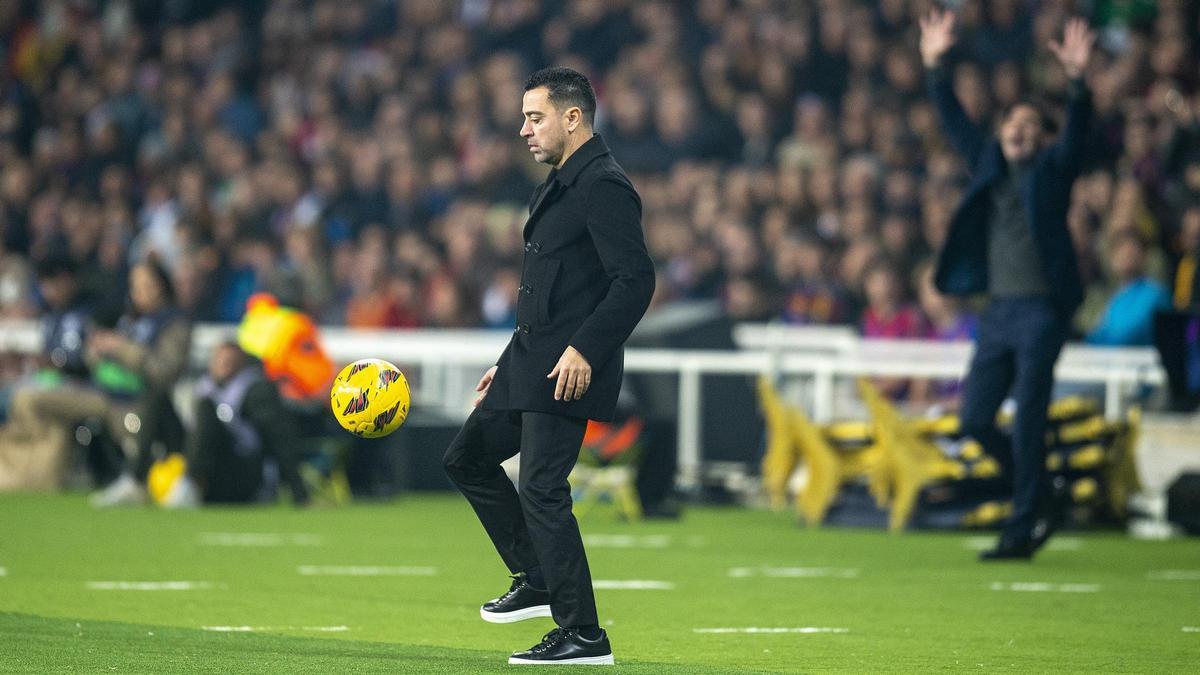 Xavi controla un balón en la banda mientras Marcelino, al fondo, protesta por algo en el Barça-Villarreal.