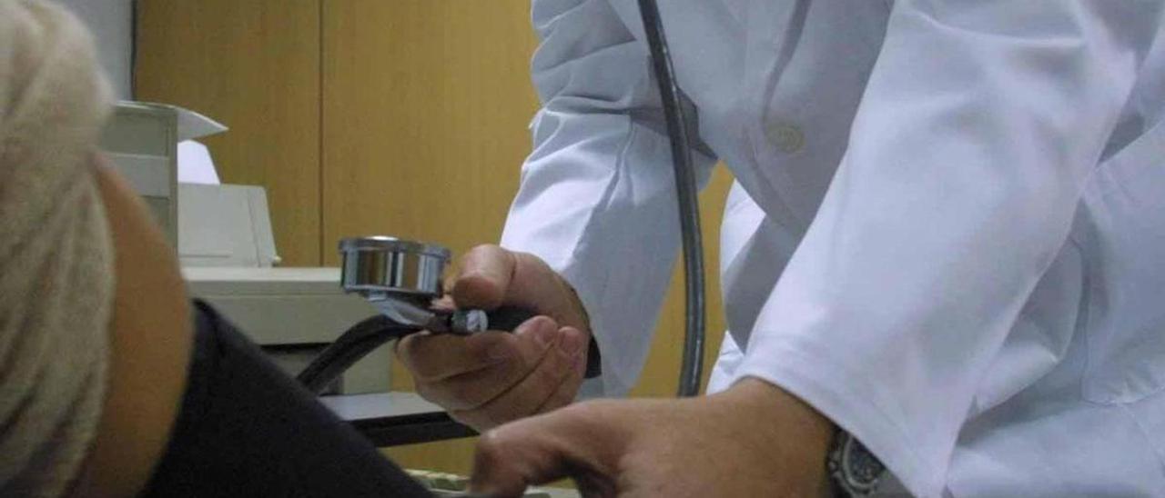 Un médico mide la tensión
a un paciente en la
consulta.  l.O.