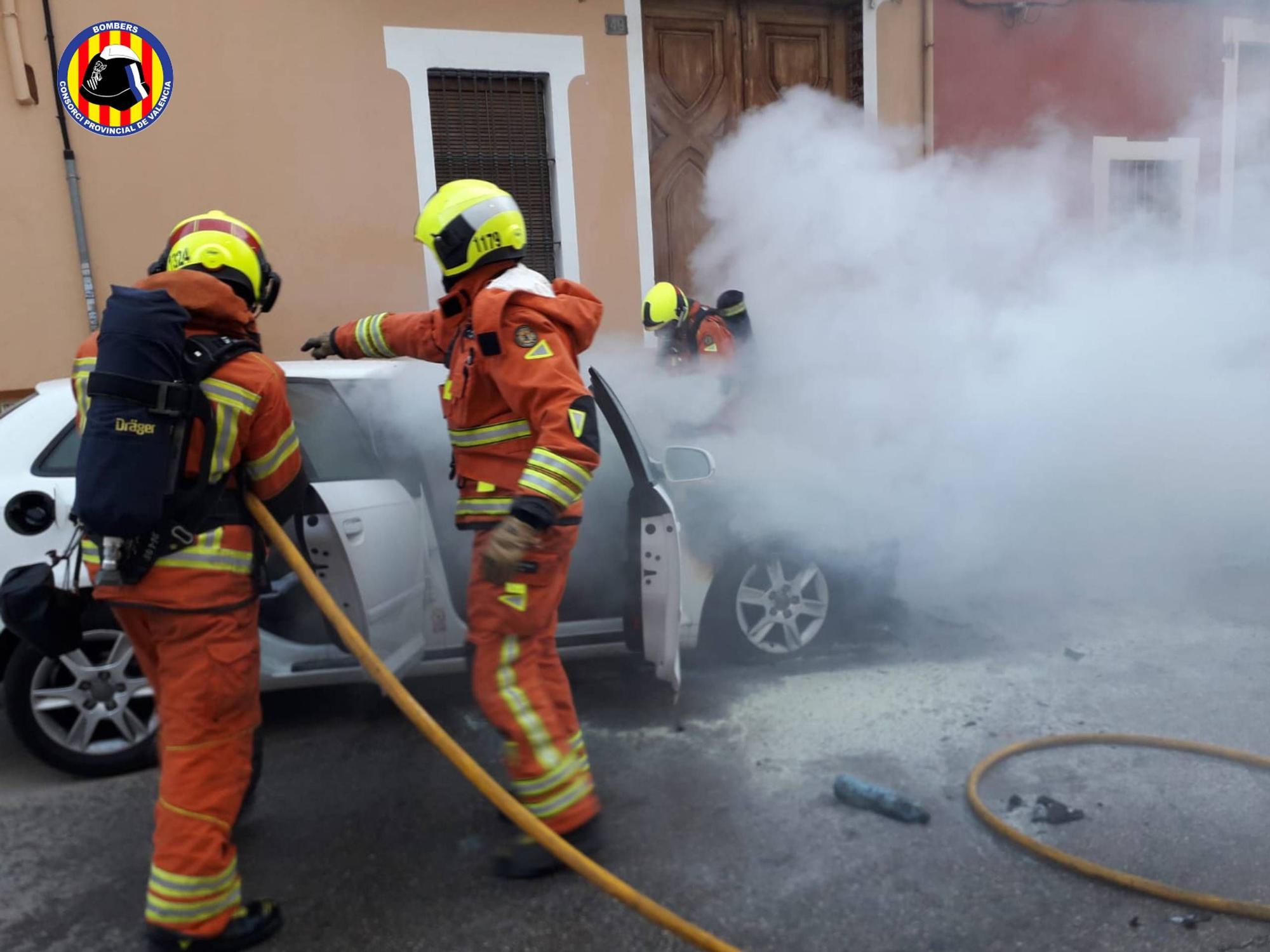 Los bomberos apagan un vehículo incendiado en plena calle en Carlet