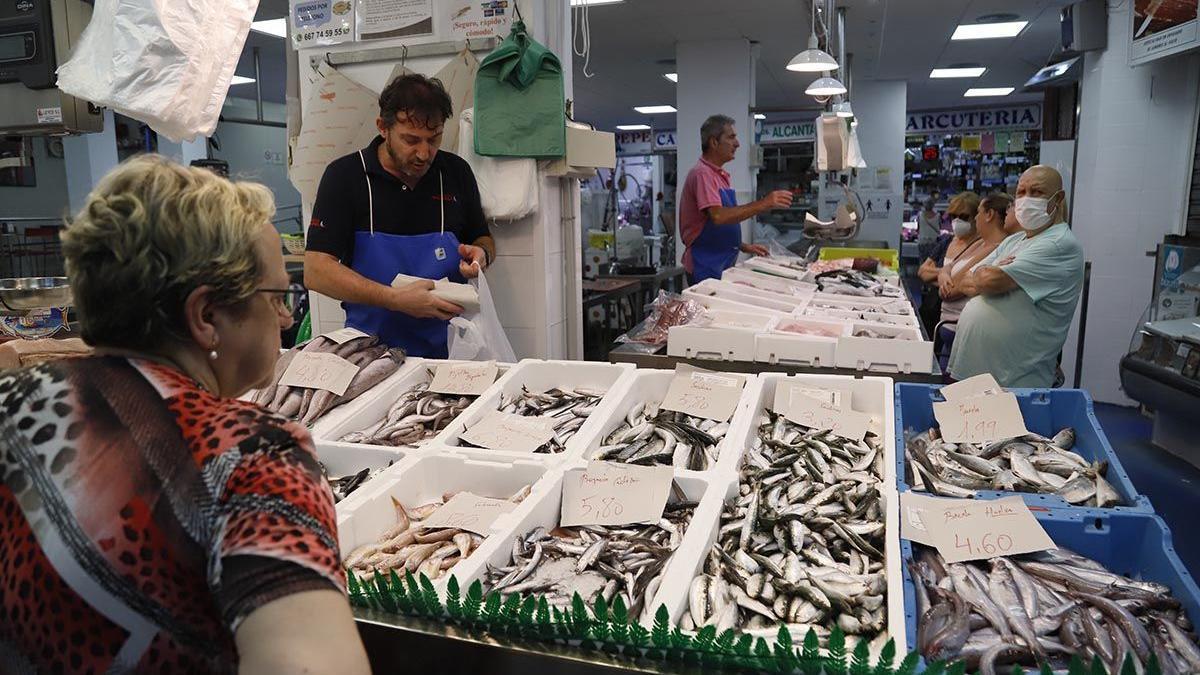 Una mujer realiza su compra en la pescadería de un mercado de abastos de Córdoba.