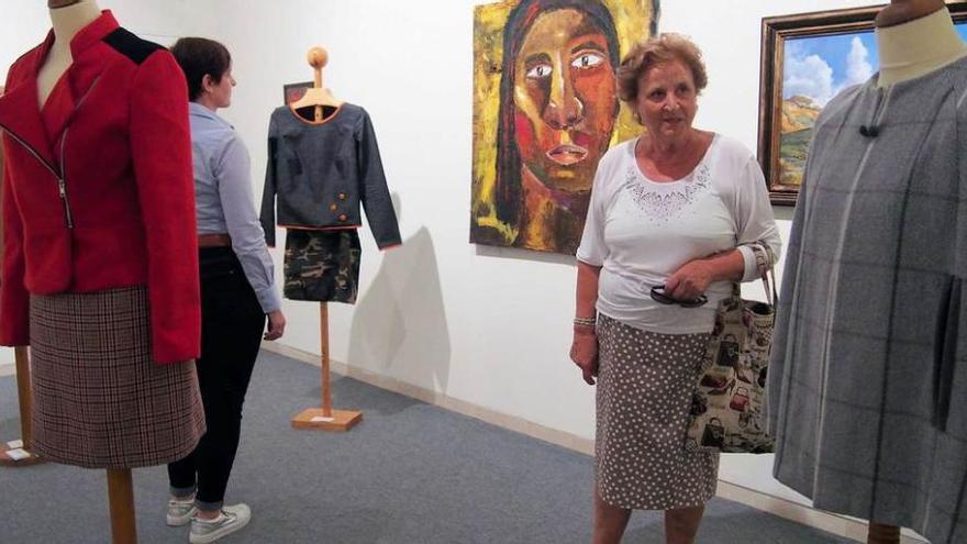 Celsa Sánchez contempla una de las piezas de la exposición. A la derecha, piezas de patchwork y talla expuestas en la Pola.