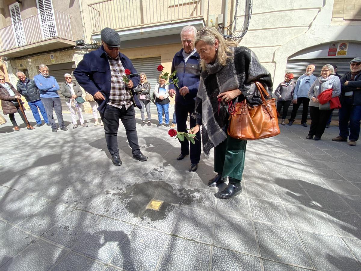 Familiars d'una persona deportada als camps de concentració nazi, dipositant una rosa al damunt d'una llamborda 'Stolpersteine' recent instal·lada a la Seu d'Urgell