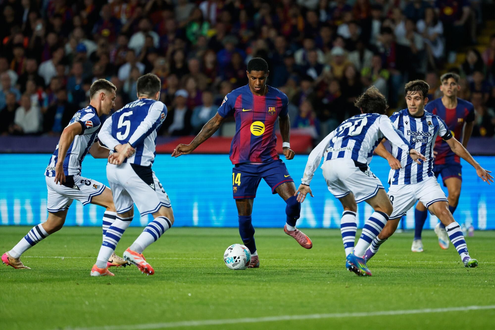 Barcelona's Marcus Rashford, center, dribbles the ball during a Spanish La Liga soccer match between FC Barcelona and Real Sociedad at the Lluis Companys Olympic Stadium in Barcelona, Spain, Sunday, Sept. 28, 2025. (AP Photo/Joan Monfort)