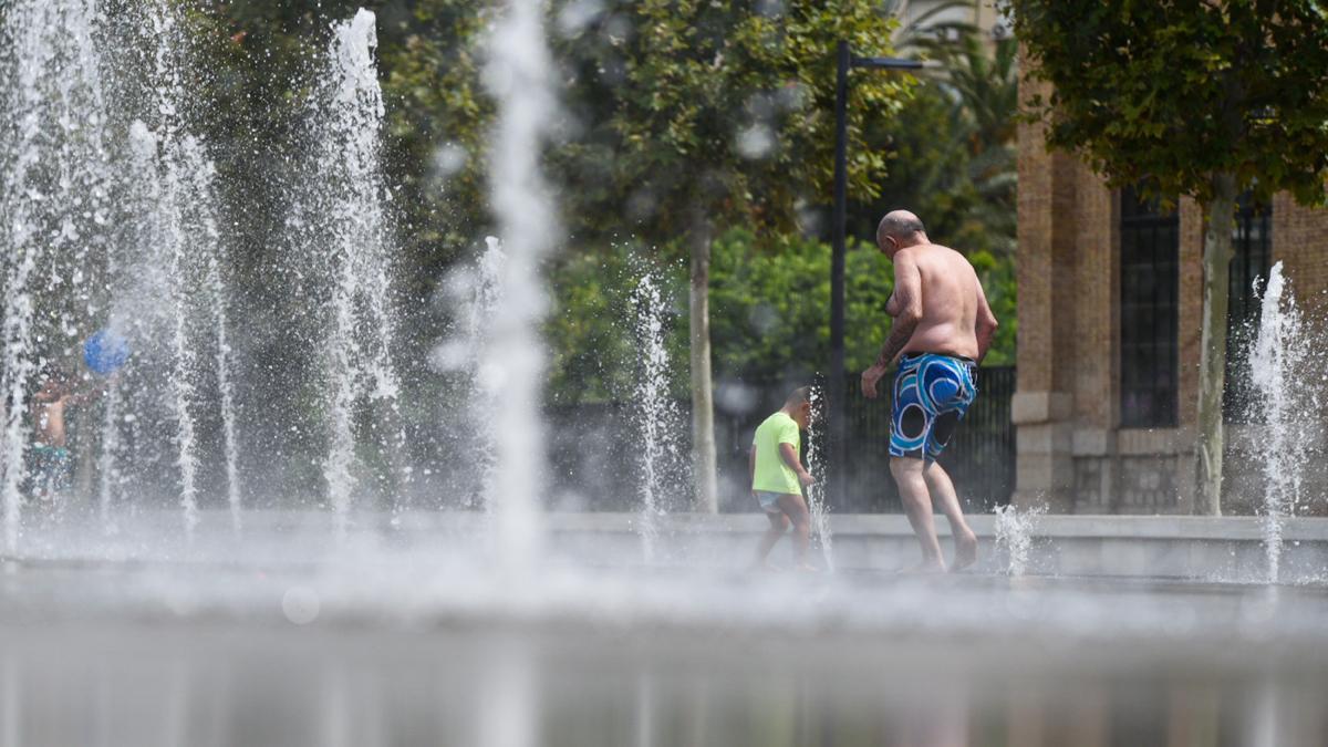 Dos personas se refrescan en una fuente del Parc Central, a 12 de agosto de 2021, en Valencia, Comunidad Valenciana (España). Como consecuencia de la ola de calor que comenzó ayer en toda España, la Comunitat Valenciana alcanzará durante la jornada de este jueves, máximas de hasta 39 grados, especialmente en el interior norte de Alicante y el interior sur de Valencia. La Aemet ha activado el aviso amarillo por las altas temperaturas en el interior de las tres provincias durante las horas centrales del día. 12 AGOSTO 2021;ALERTA AMARILLA;CALOR;TEMPERATURAS;VALENCIA;39 GRADOS;BOCHORNO;OLA DE CALOR;VERANO Jorge Gil / Europa Press 