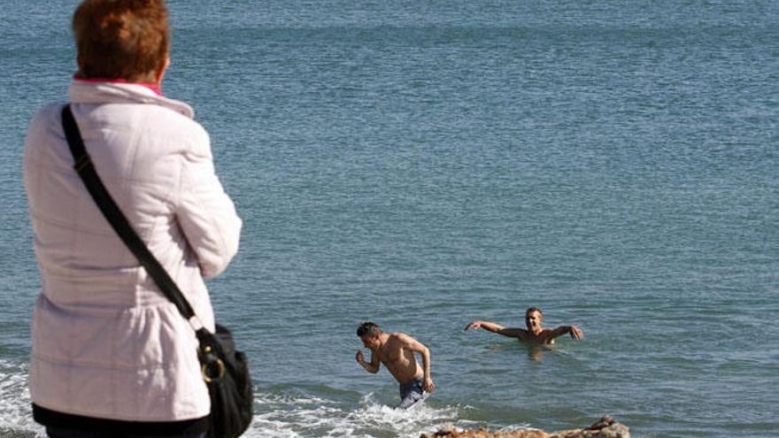 Unos bañistas precoces en las aguas de La Malagueta.