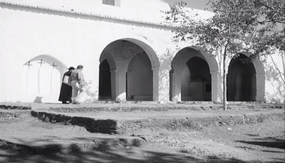 El protagonista, amb un capellà a l'església de Sant Carles.