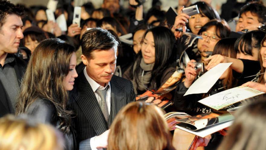 La actriz estadounidense Angelina Jolie (i) y el actor Brad Pitt (d) firman autógrafos a su llegada al estreno de la película ´El curioso caso de Benjamin Button´, del estadounidense David Fincher, en Tokio (Japón), el 29 de enero de 2009. La cinta llegará a las salas japonesas el próximo 7 de febrero.