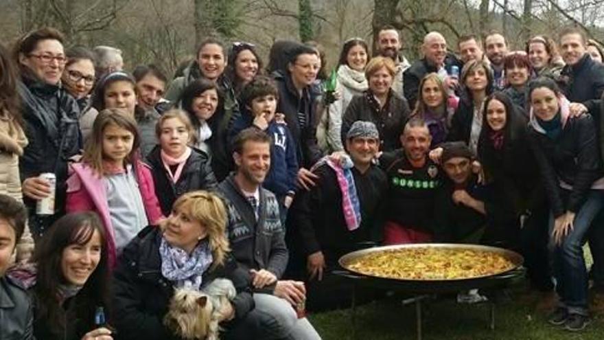 Algunos de los asistentes al encuentro posan con la paella.