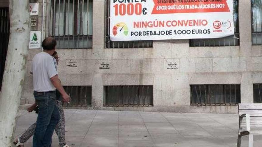 Pancarta que pide convenios por encima de 1.000 euros.