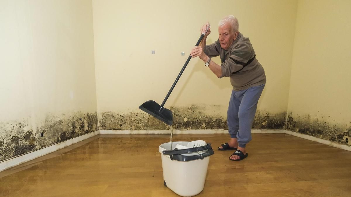 Antonio Rodríguez, recoge el agua del alcantarillado que se filtra por la pared de su casa, en el Risco de San Nicolás.