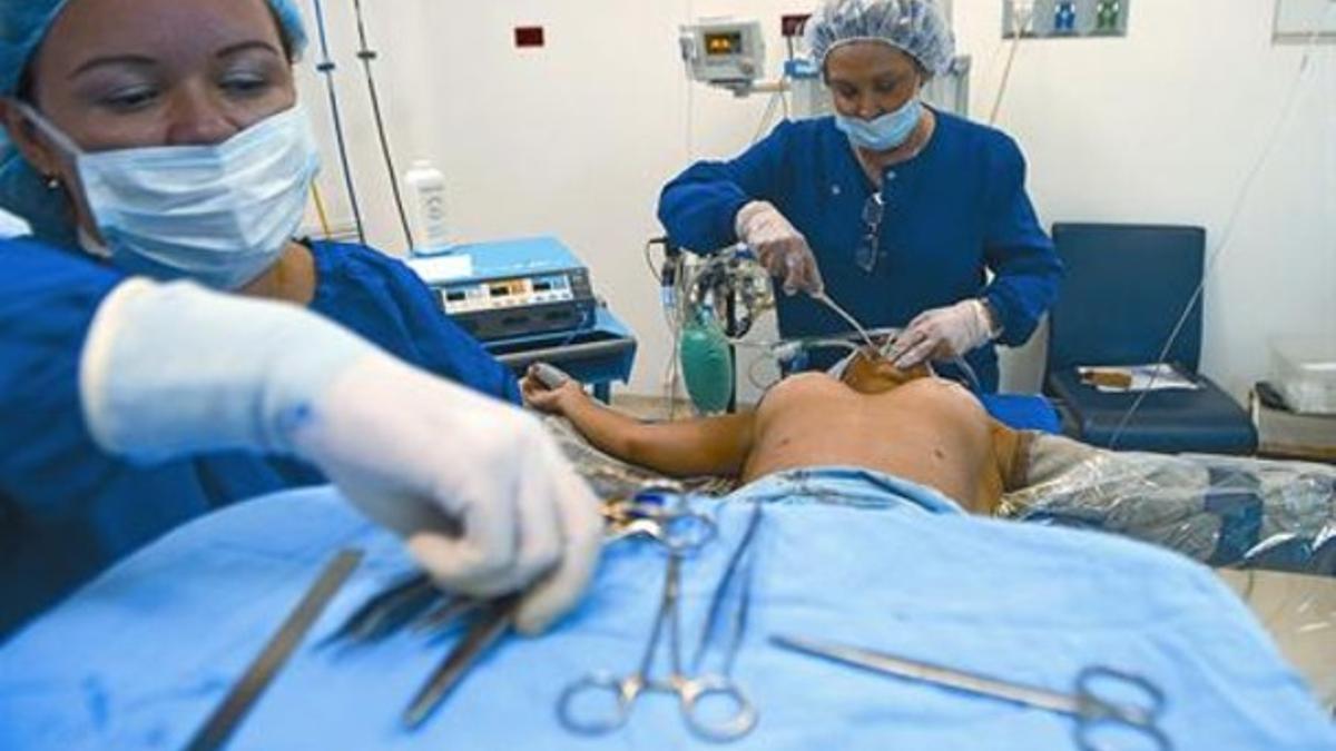 Unos cirujanos extraen una prótesis PIP a una paciente en la ciudad colombiana de Medellín.