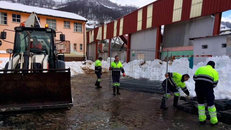 Operarios municipales colocan el cierre perimetral en Felechosa.