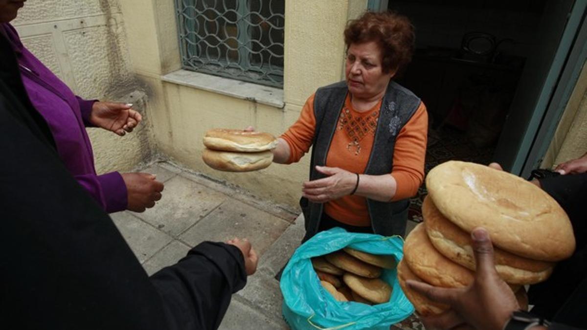 Una mujer reparte pan en una iglesia del centro de Atenas, el pasado abril.