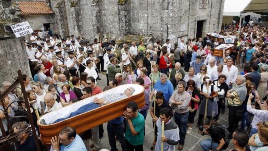 Cuatro de los seis ataúdes, a la salida de la iglesia en procesión. // Marta G. Brea