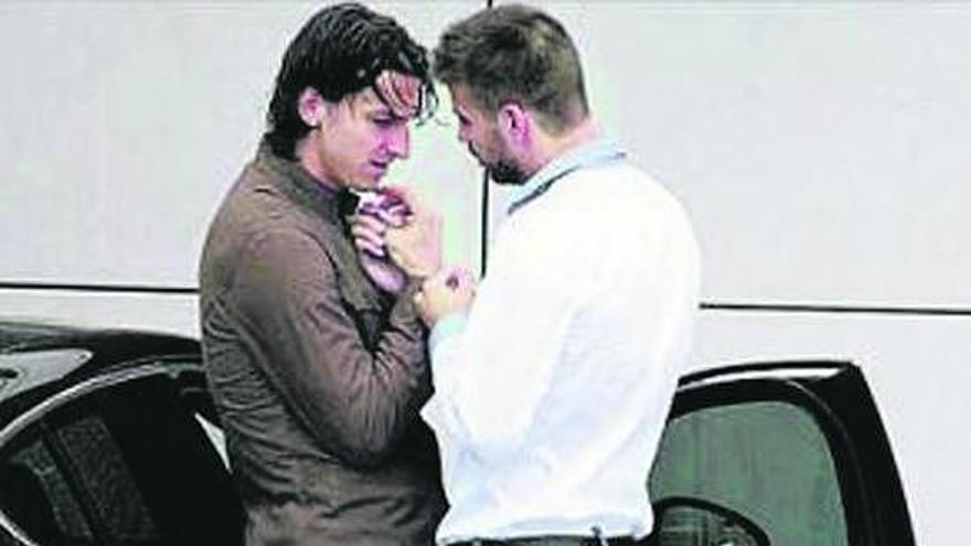 La imagen de la polémica: Ibrahimovic, apoyado en su coche, agarra de la mano a Piqué, de espaldas.