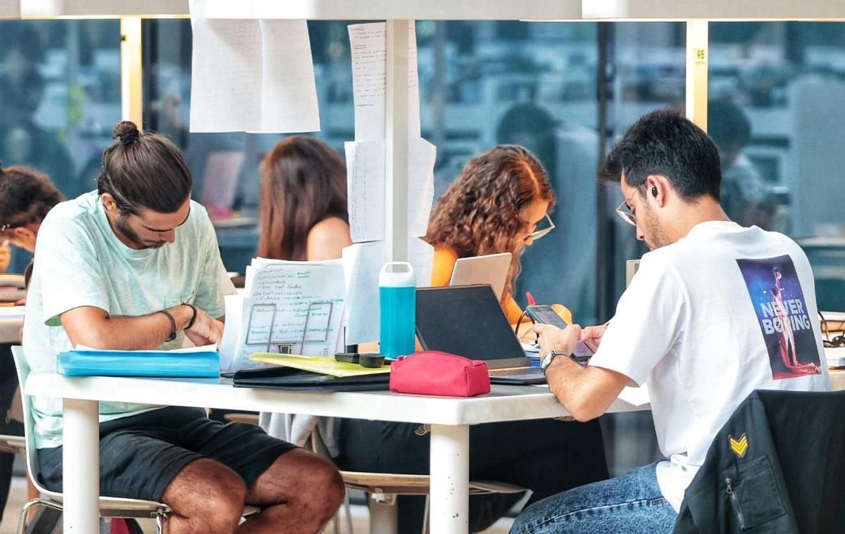 Varios estudiantes en una biblioteca.