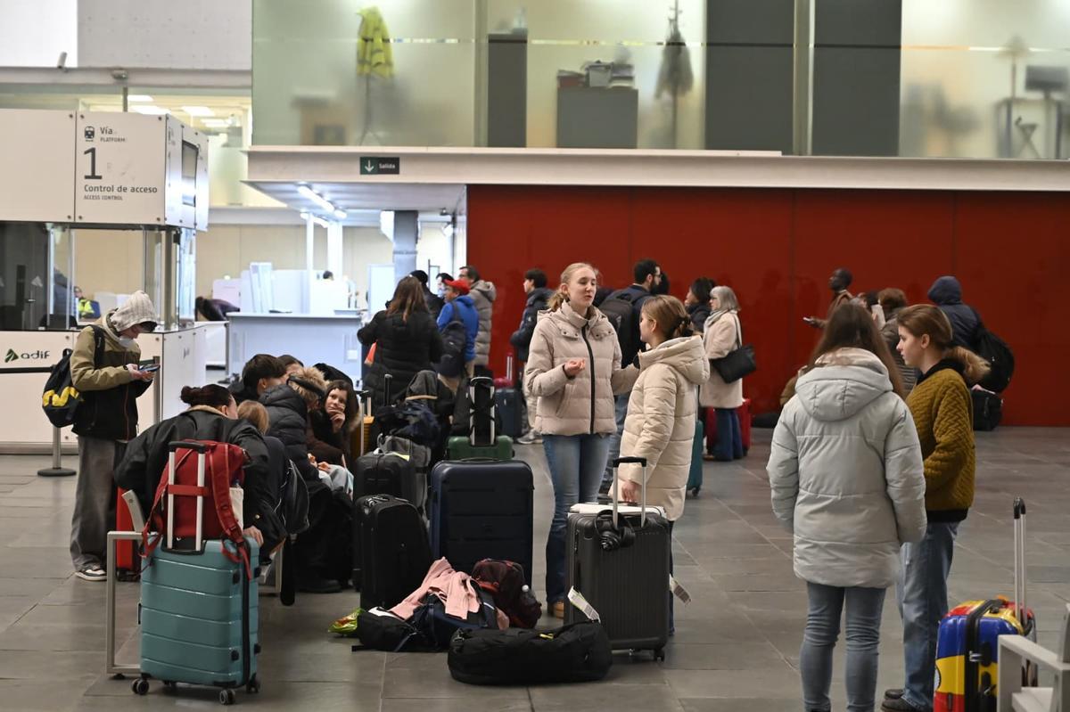 Varios pasajeros esperan la salida de sus trenes este lunes en la estación Delicias.