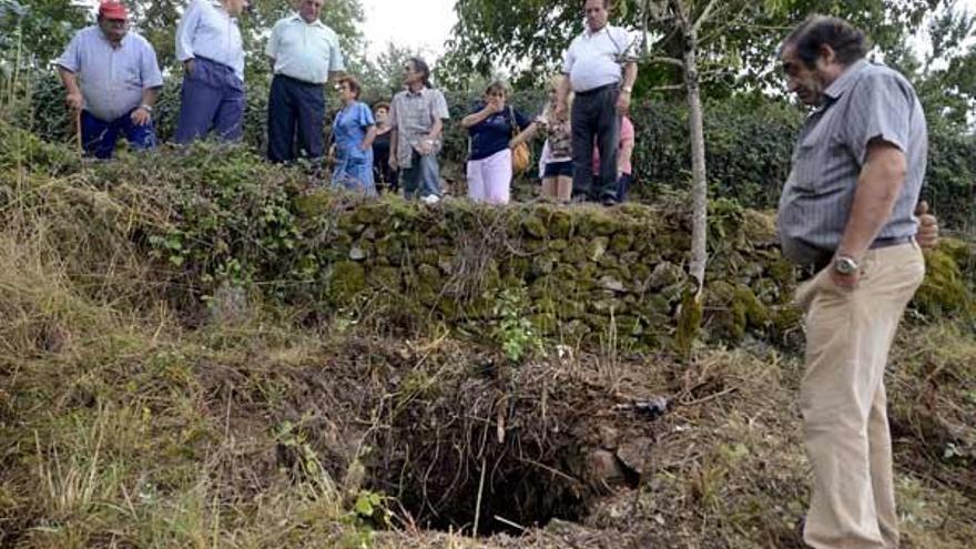 Vecinos de San Pedro de A Mezquita, en A Merca (Ourense), ante el pozo donde se ha encontrado esta tarde el cuerpo del hombre de unos 68 años de edad, natural de A Telleira (Taboadela), que estaba desaparecido desde la una de la madrugada, y fue localizado en el pozo por causas que todavía se desconocen.