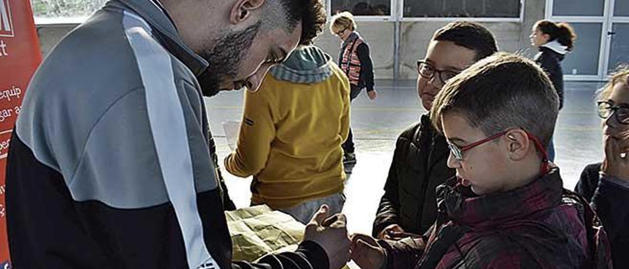 El jugador del Palma Futsal, Joaki, firma un autÃ³grafo a un alumno del CEIP Montaura.