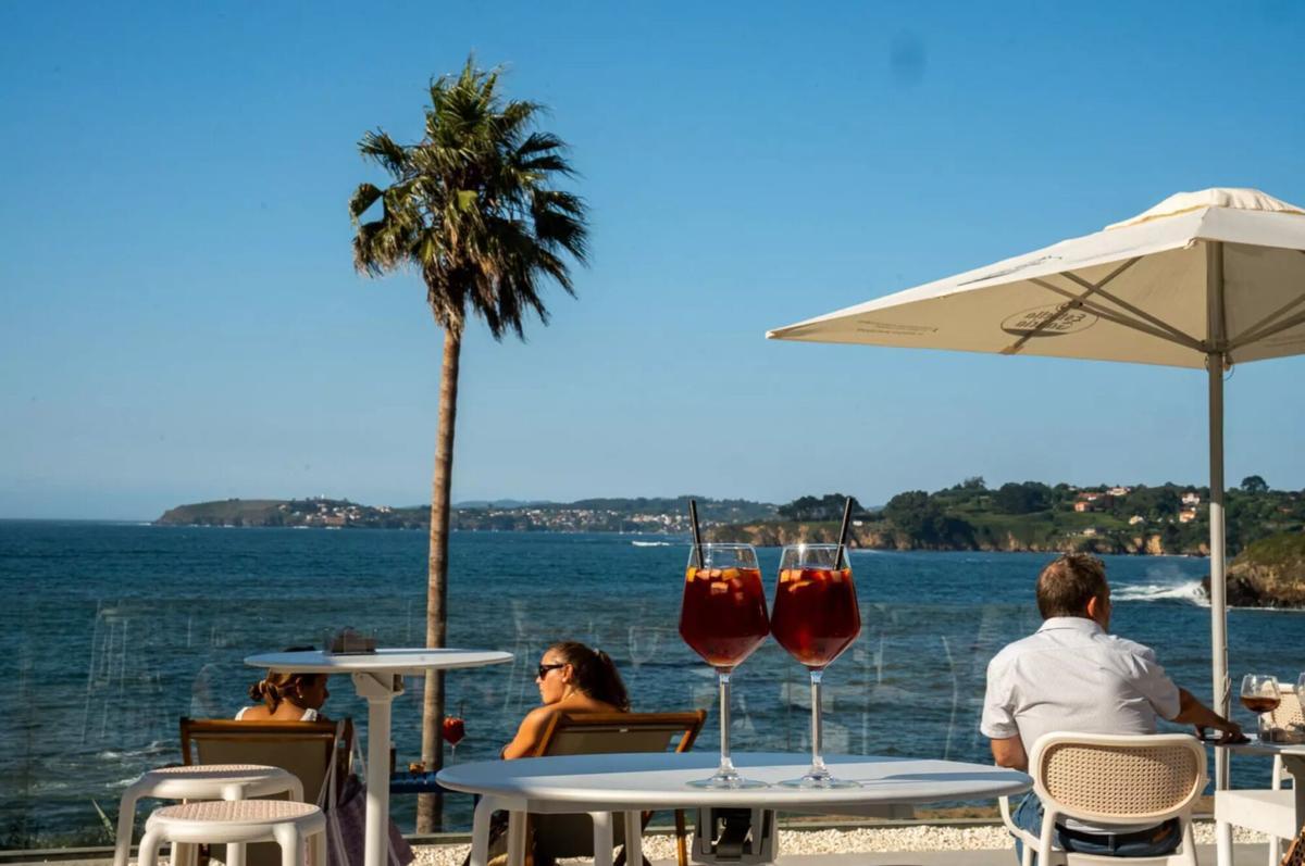 Los clientes disfrutan de sus copas en esta singular terraza de A Coruña con vistas al Atlántico.